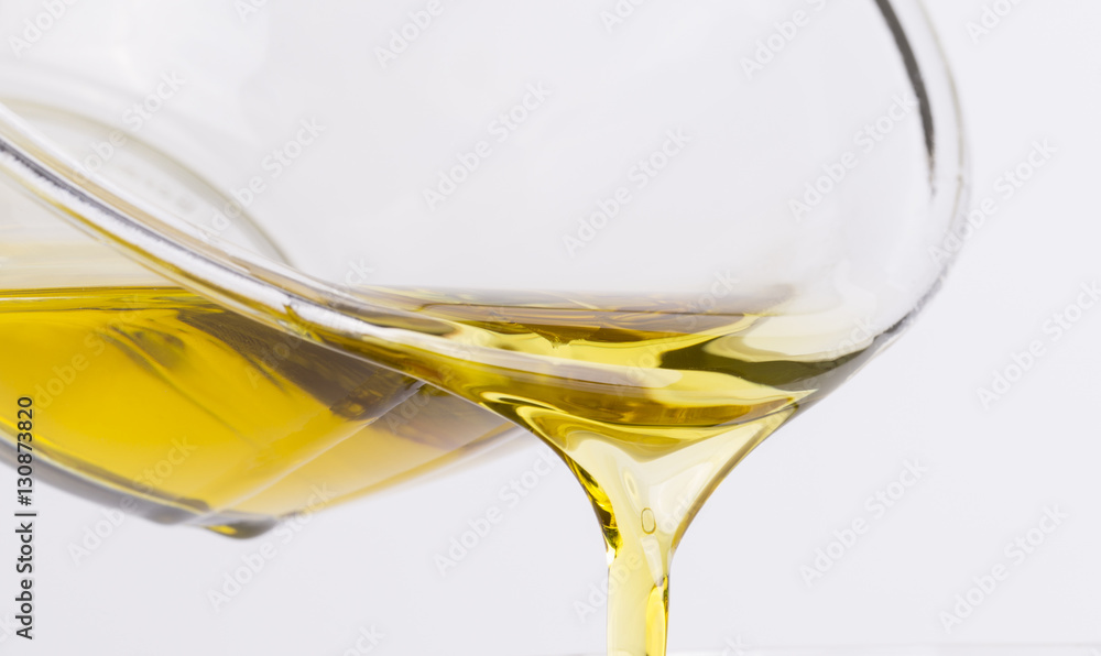 Olive oil flows from a glass bowl Olive oil flows from a glass bowl
