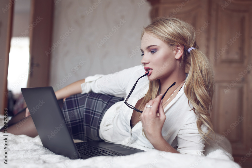 Young sexy smart blonde woman flirting online on bed Stock 写真 | Adobe Stock