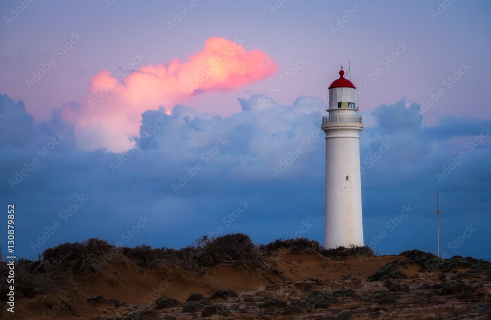 Lighthouse at sunset with moody clouds