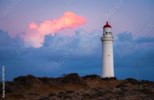 Lighthouse at sunset with moody clouds