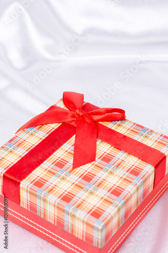 Gift box with bow over white satin