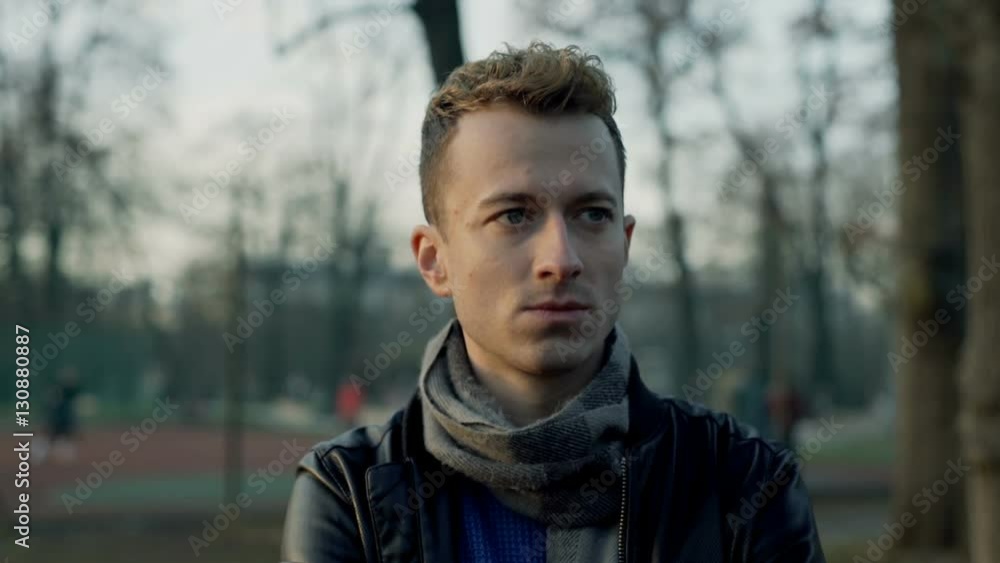 Pensive man standing in the park and look thoughtful, steadycam shot
Pensive man standing in the park and look thoughtful, steadycam shot