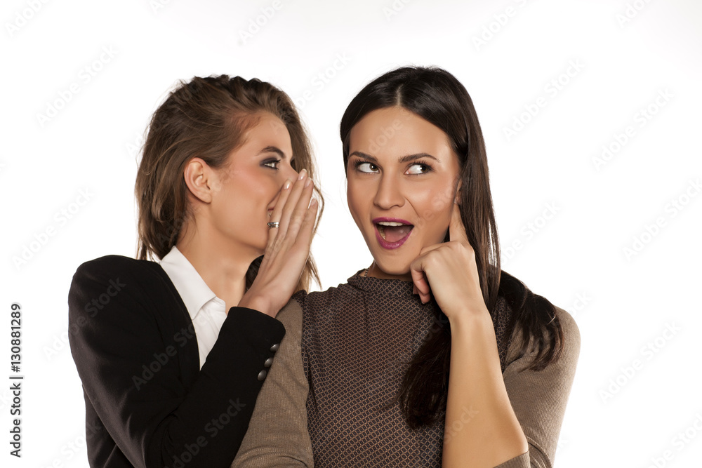 young gossip girl whisper to her friend's ear young gossip girl whisper to her friend's ear
