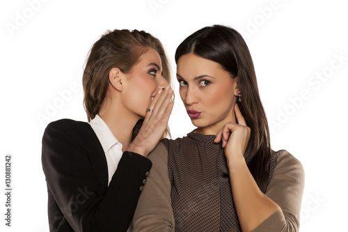 Foto young gossip girl whisper to her friend's ear