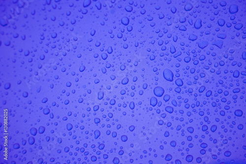 Rain drops on blue metal surface. Background and textures.
