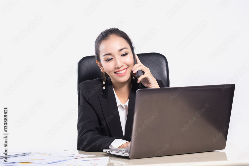 Beautiful business Asian woman smiling while talking on the smartphone at her office desk on white background Beautiful business Asian woman smiling while talking on the smartphone at her office desk on white background