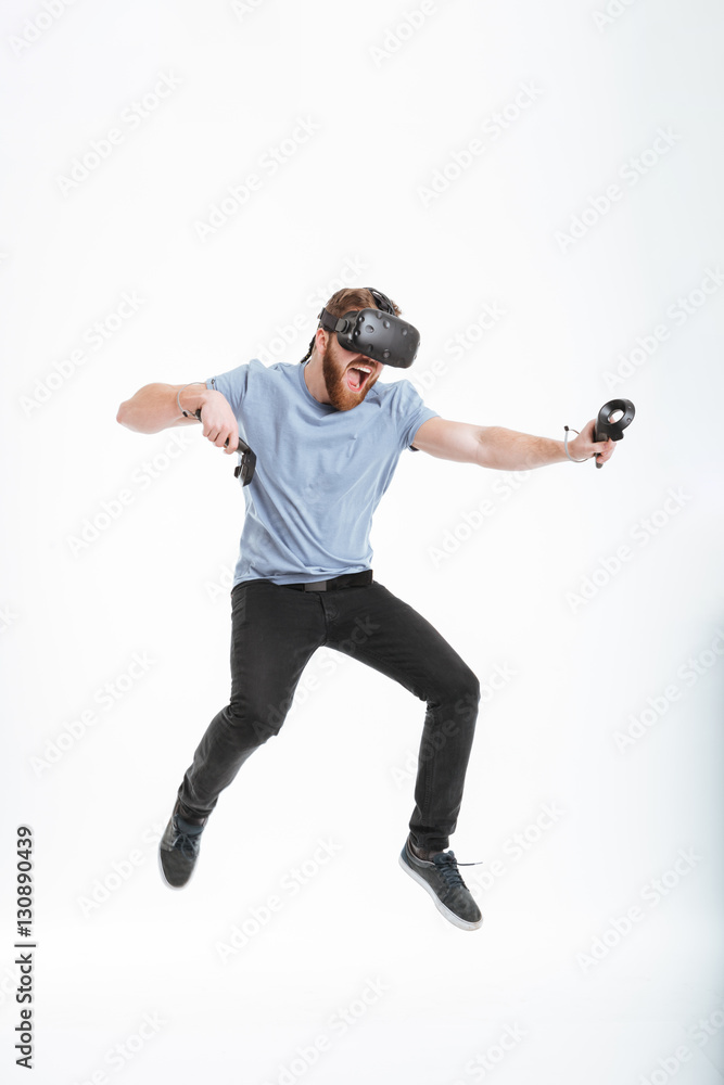 Happy bearded man wearing virtual reality device while jumping Happy bearded man wearing virtual reality device while jumping