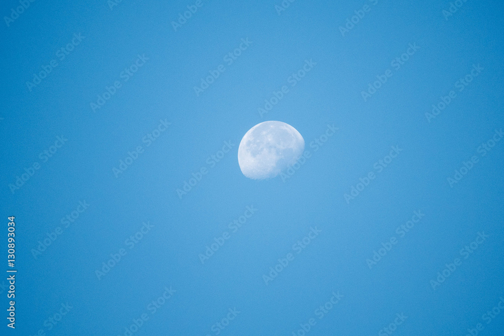 half moon in morning with clear blue sky