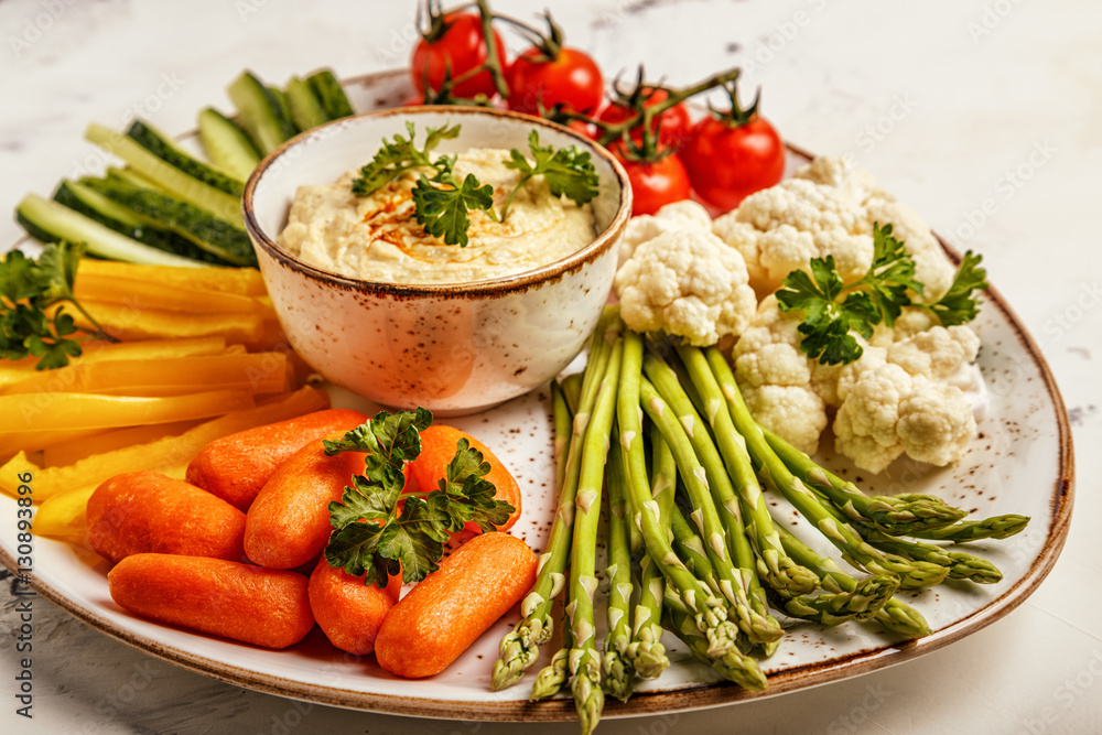 Healthy homemade hummus with assorted fresh vegetables.