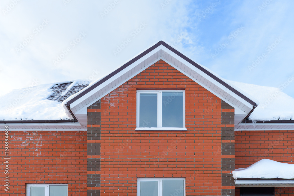 brick apartment house with a snow-covered roof