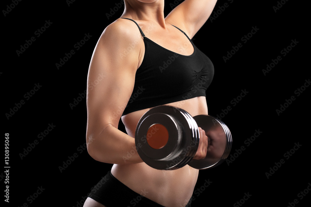 Fototapeta premium Athletic girl with dumbbells in hand.