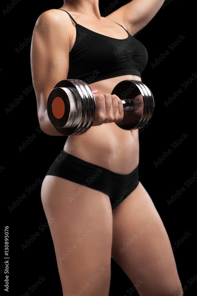 Fototapeta premium Athletic girl with dumbbells in hand.