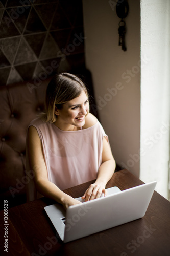 Young woman with laptop sit...