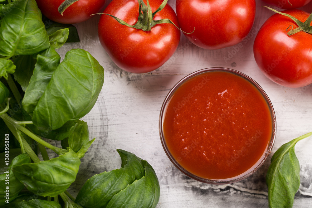 Fresh tomatoes and basil leaves on white background Fresh tomatoes and basil leaves on white background