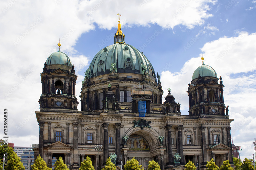 View of Berliner Dom with cloudy sky in the background in Berlin. Majestic 1800s cathedral with an organ with 7,000 pipes, plus royal tombs & a dome for city views.
