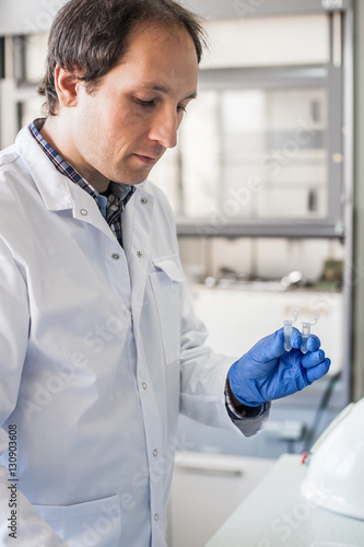 Male lab technician holding a test tube with sample © guruXOX