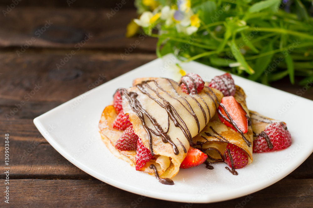 Pancakes with strawberries, topped chocolate. Wooden table. Top view