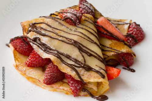 Pancakes with strawberries, topped  chocolate.White background. Top view