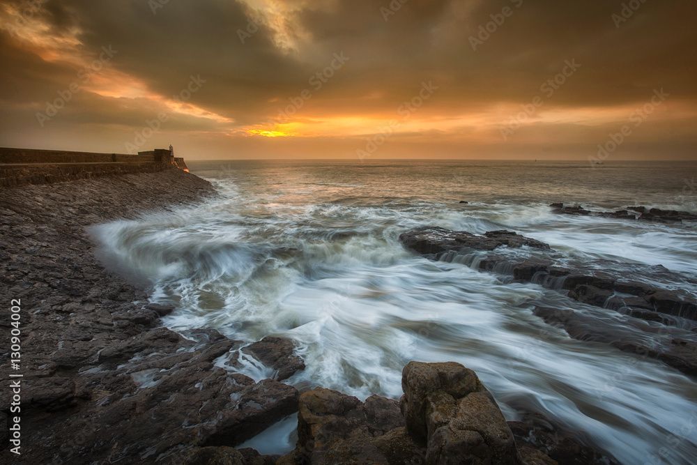 Sunrise and a choppy sea at Porthcawl lighthouse in South Glamorgan, South Wales Sunrise and a choppy sea at Porthcawl lighthouse in South Glamorgan, South Wales