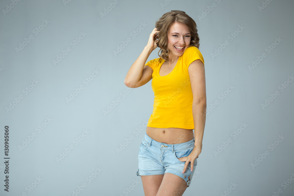 Image of happy young woman wearing yellow shirt and jeans shorts Stock ...