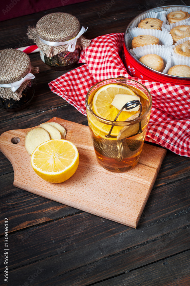 cup black tea with lemon, ginger and cookies on dark wood cup black tea with lemon, ginger and cookies on dark wood