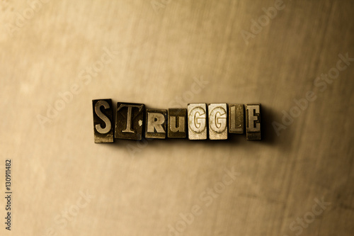 Photography STRUGGLE - close-up of grungy vintage typeset word on metal backdrop