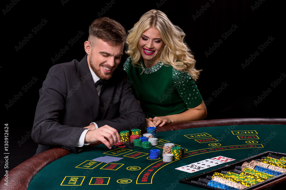 View of young, confident, man with the lady while he's playing poker game. View of young, confident, man with the lady while he's playing poker game.