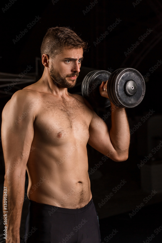 Muscular bodybuilder handsome man doing exercises in outdoor gym naked torso