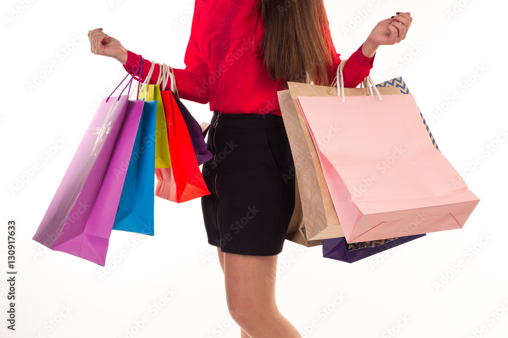 Woman holds shopping purchases, many colorful paper bags in arms