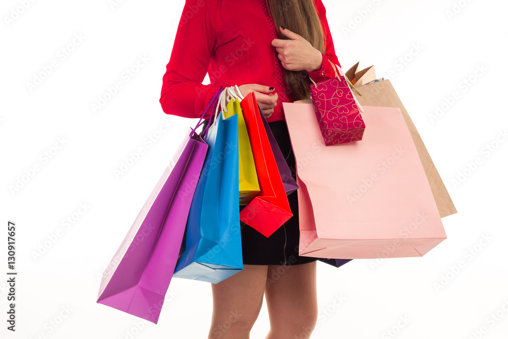 Woman holds shopping purchases, many versicoloured paper bags in
