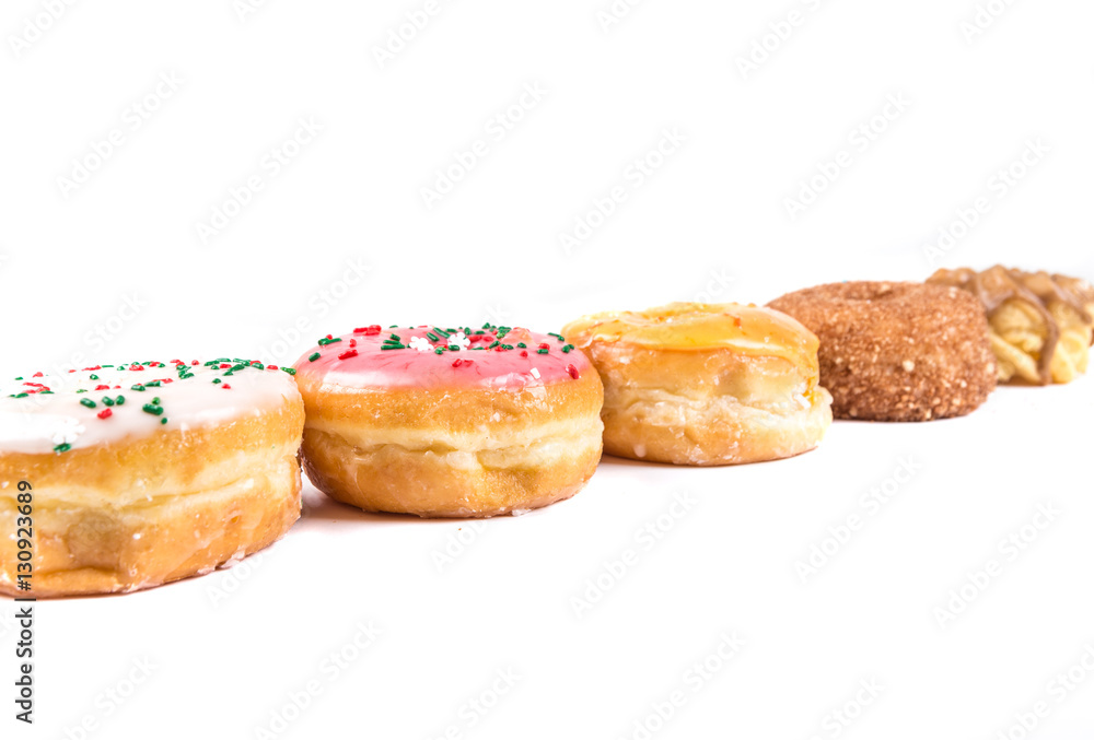 Frosted donut lineup shallow depth of field isolated on a white background