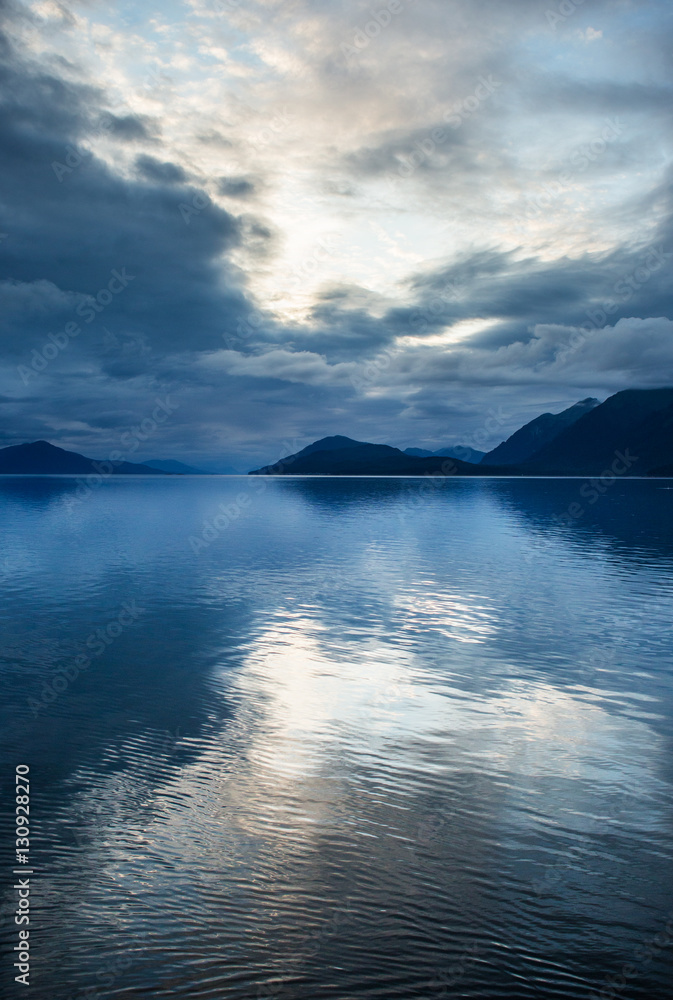Clouds are reflected in water in the fjords of Alaska. Alaska. USA. An excellent illustration.