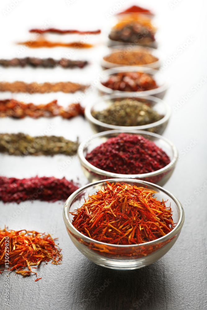 Various spices in glass bowls on grey table Various spices in glass bowls on grey table
