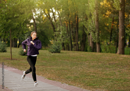 Fototapeta Naklejka Na Ścianę i Meble -  Young sporty woman jogging in a park