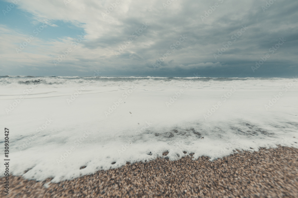 Obraz premium Mare tempestoso con nuvole grigie nel cielo.