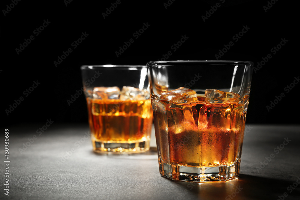 Glasses of whisky on grey textured table closeup Glasses of whisky on grey textured table closeup