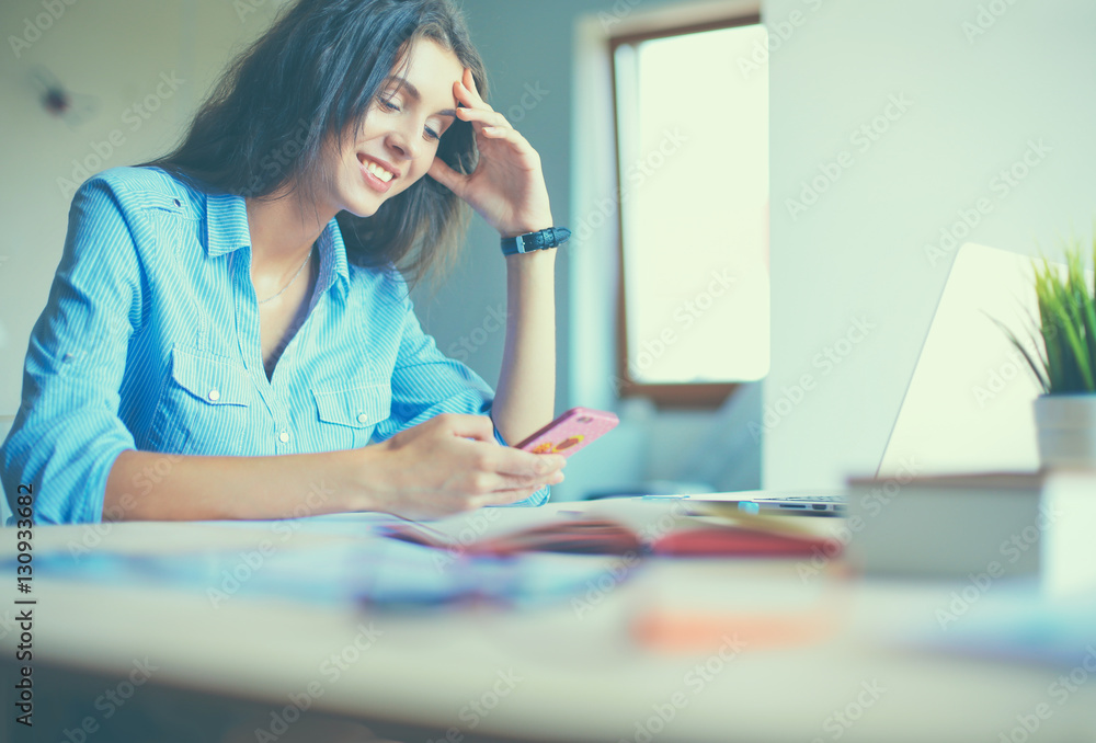 Young woman sitting at office table with laptop Young woman sitting at office table with laptop