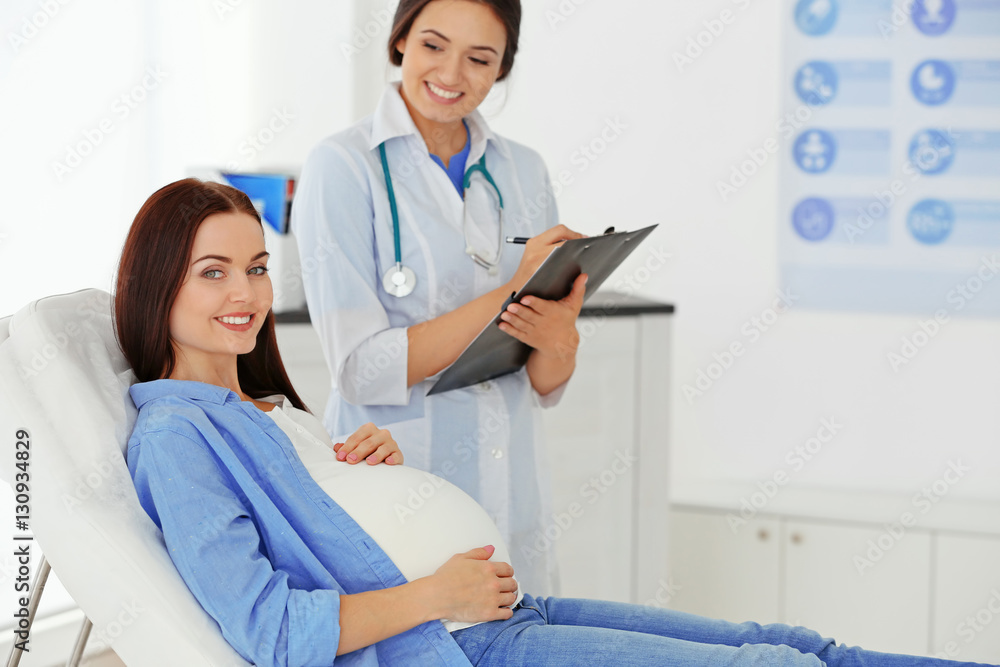 Fototapeta premium Young pregnant woman visiting doctor