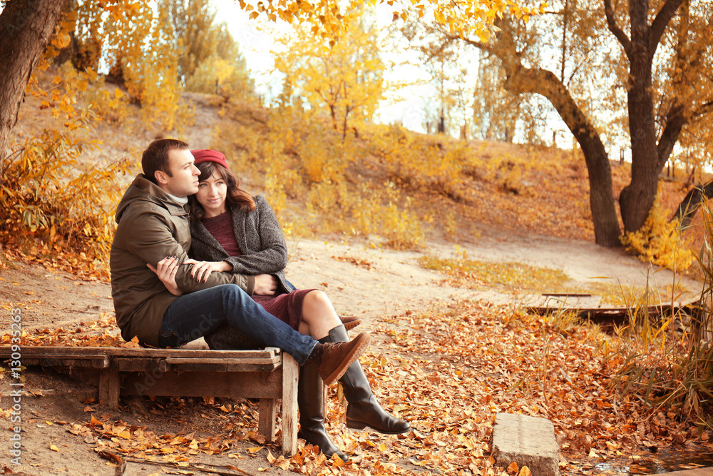 Fototapeta premium Beautiful young couple resting in autumn park
