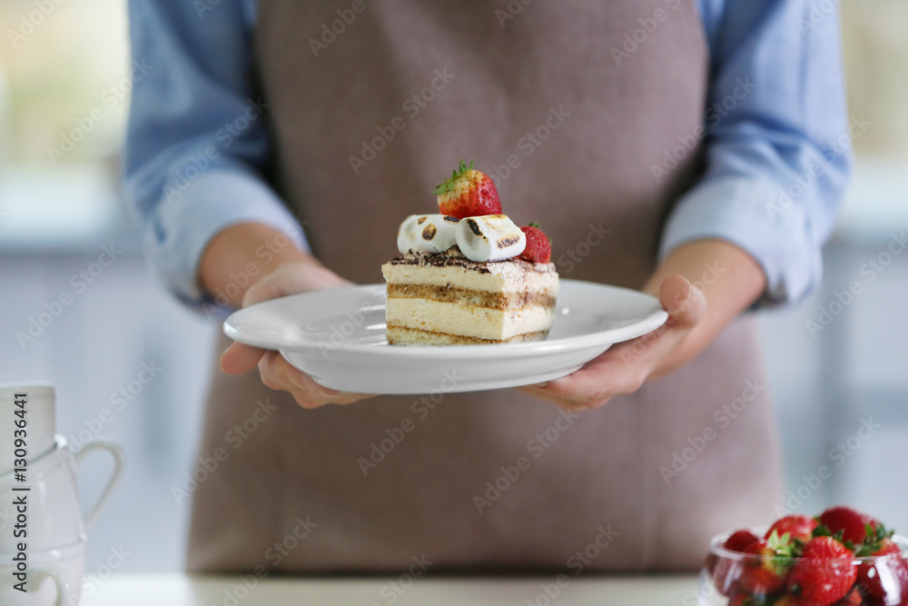 Female hands holding tasty dessert with strawberry, closeup