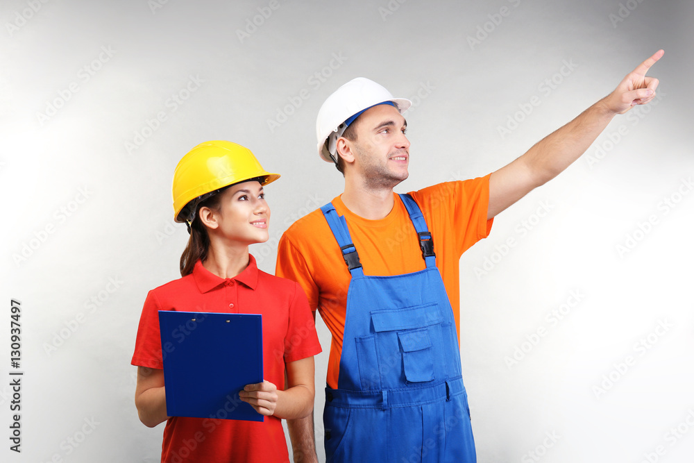 Warehouse workers with clipboard discussing something, on light background Warehouse workers with clipboard discussing something, on light background