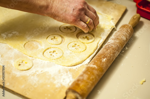 preparare i biscotti di natale con farina uova zucchero e marmellata con il mattarello