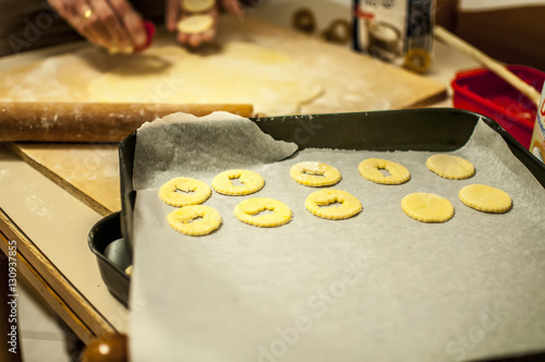 preparare i biscotti di natale con farina uova zucchero e marmellata con il mattarello