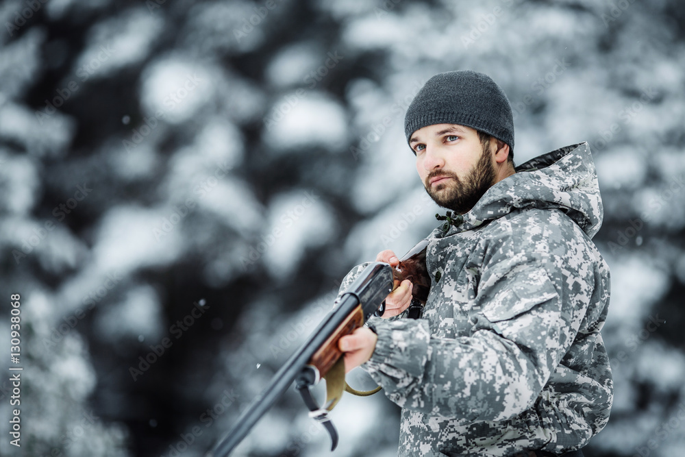 Male hunter in camouflage looking for his target or prey .Winter Male hunter in camouflage looking for his target or prey .Winter
