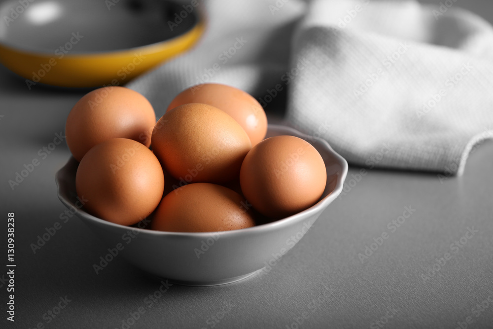 Raw eggs in bowl on kitchen table Raw eggs in bowl on kitchen table