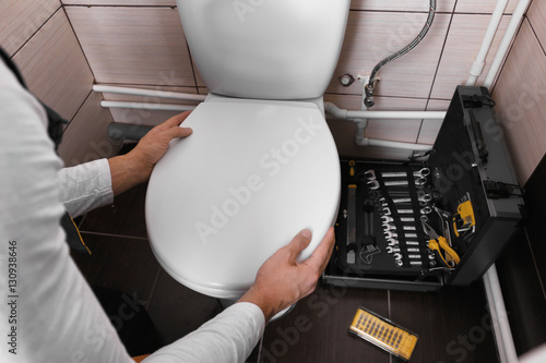 Foto Plumber fixing toilet seat lid