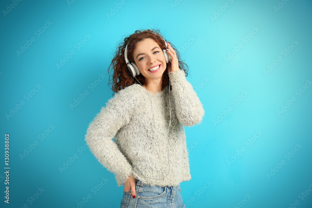 Portrait of expressive young model with earphones on blue background Portrait of expressive young model with earphones on blue background