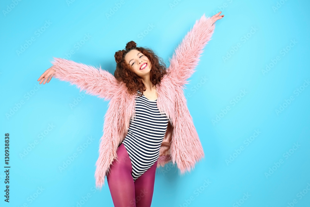 Portrait of expressive young model in pink fur coat on blue background Portrait of expressive young model in pink fur coat on blue background