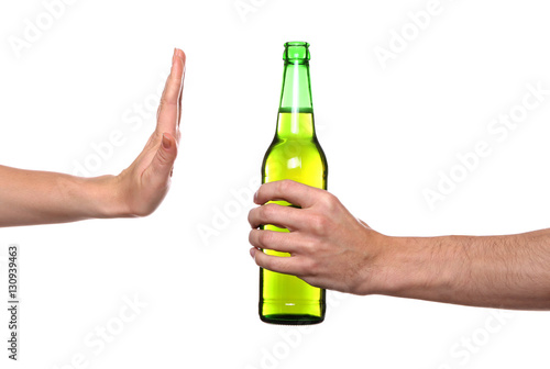 Female hand refusing bottle with beer on white background