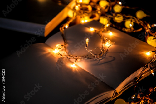 Close up view of open book and beautiful garland on table